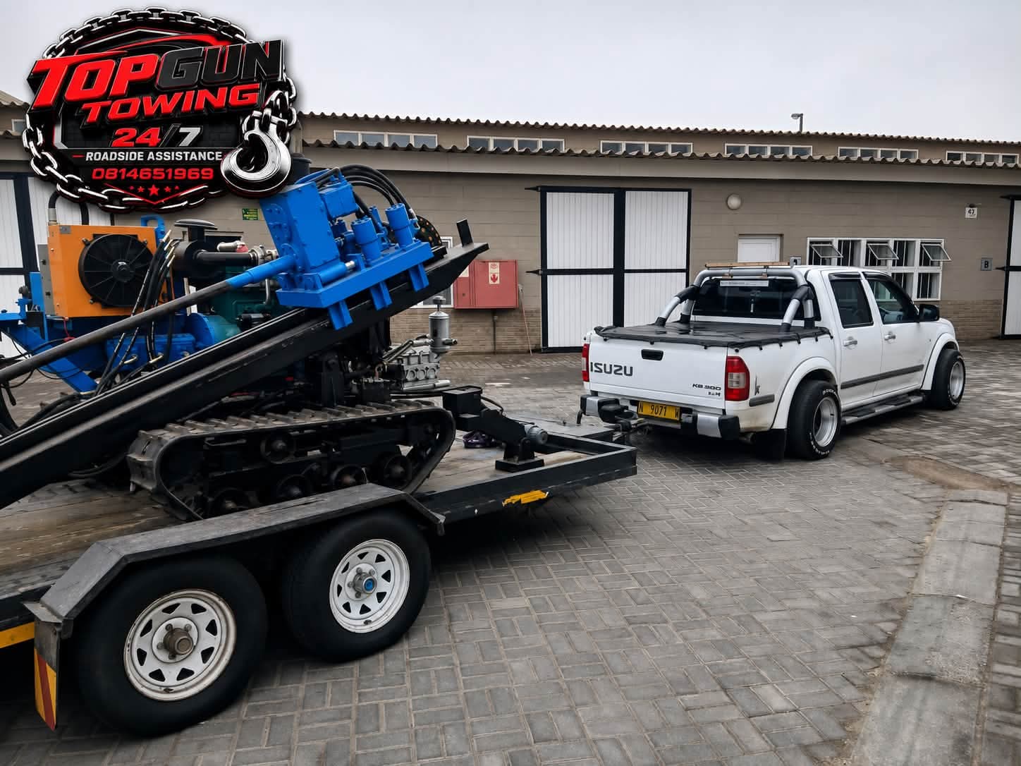 Isuzu hauling heavy machinery on trailer